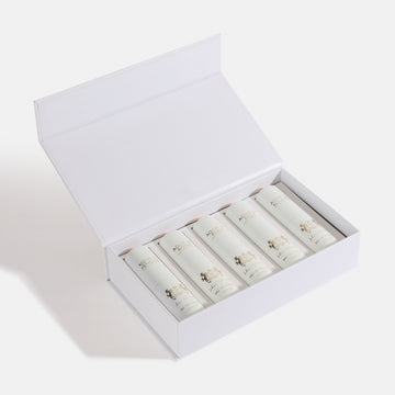 5 PC GIFT SET WHITE EDP Open white box containing rolled-up items on a light gray background. House Of Perfumes India