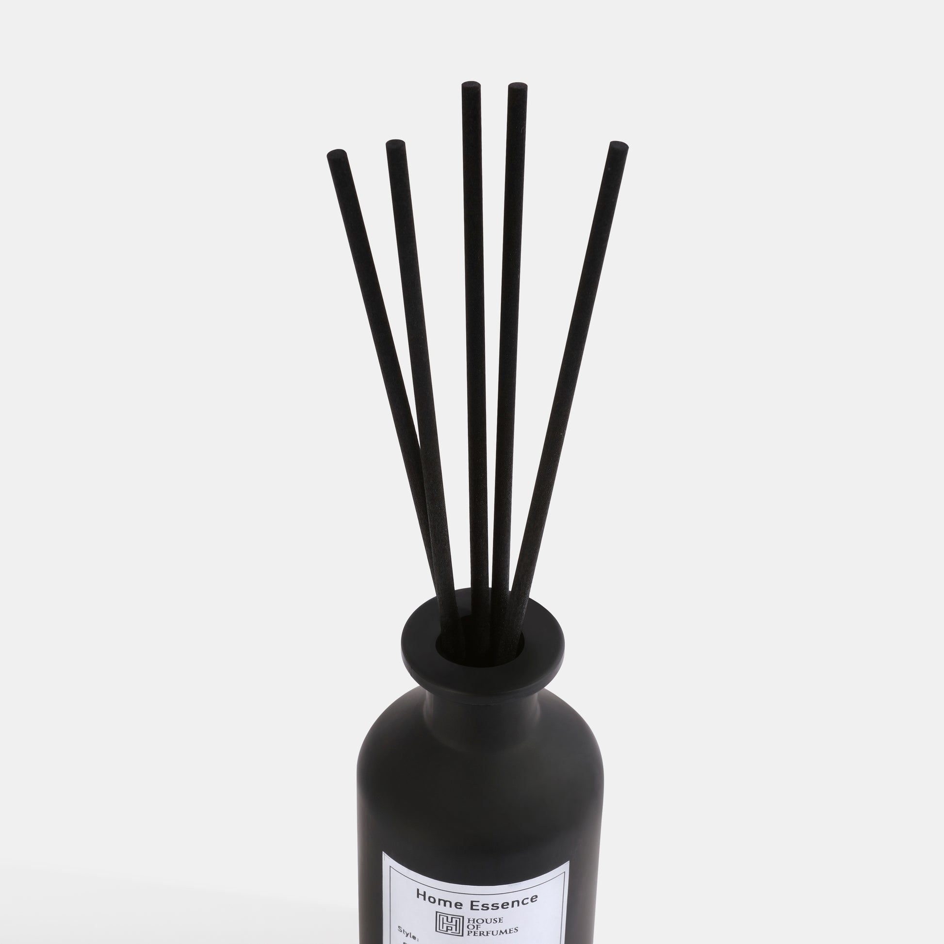 Black diffuser bottle with sticks on a white background