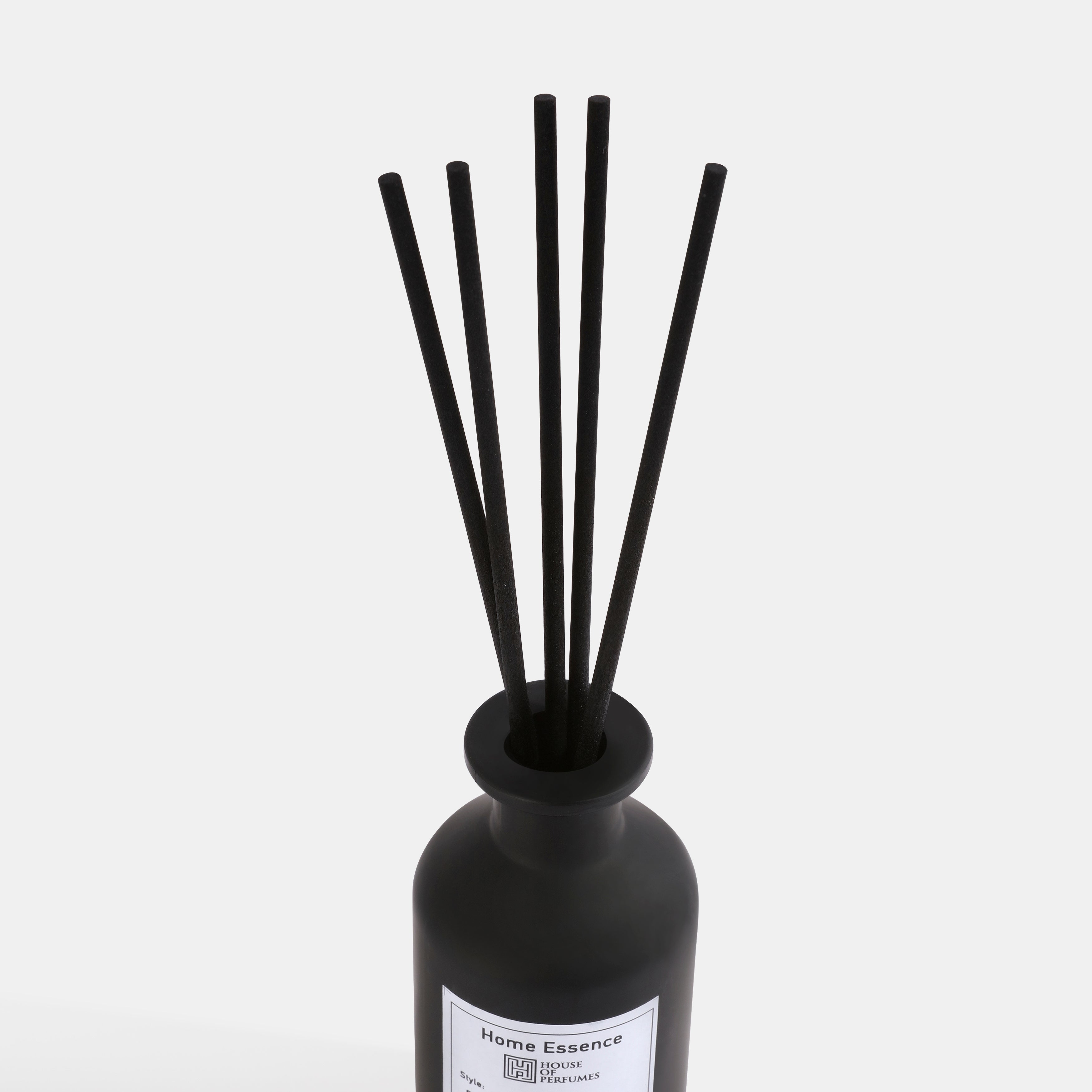 Black diffuser bottle with sticks on a white background