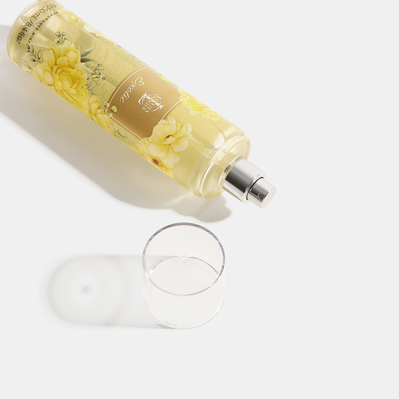 Exotic Bottle of yellow floral-scented room spray with a glass on a white background. HOP India