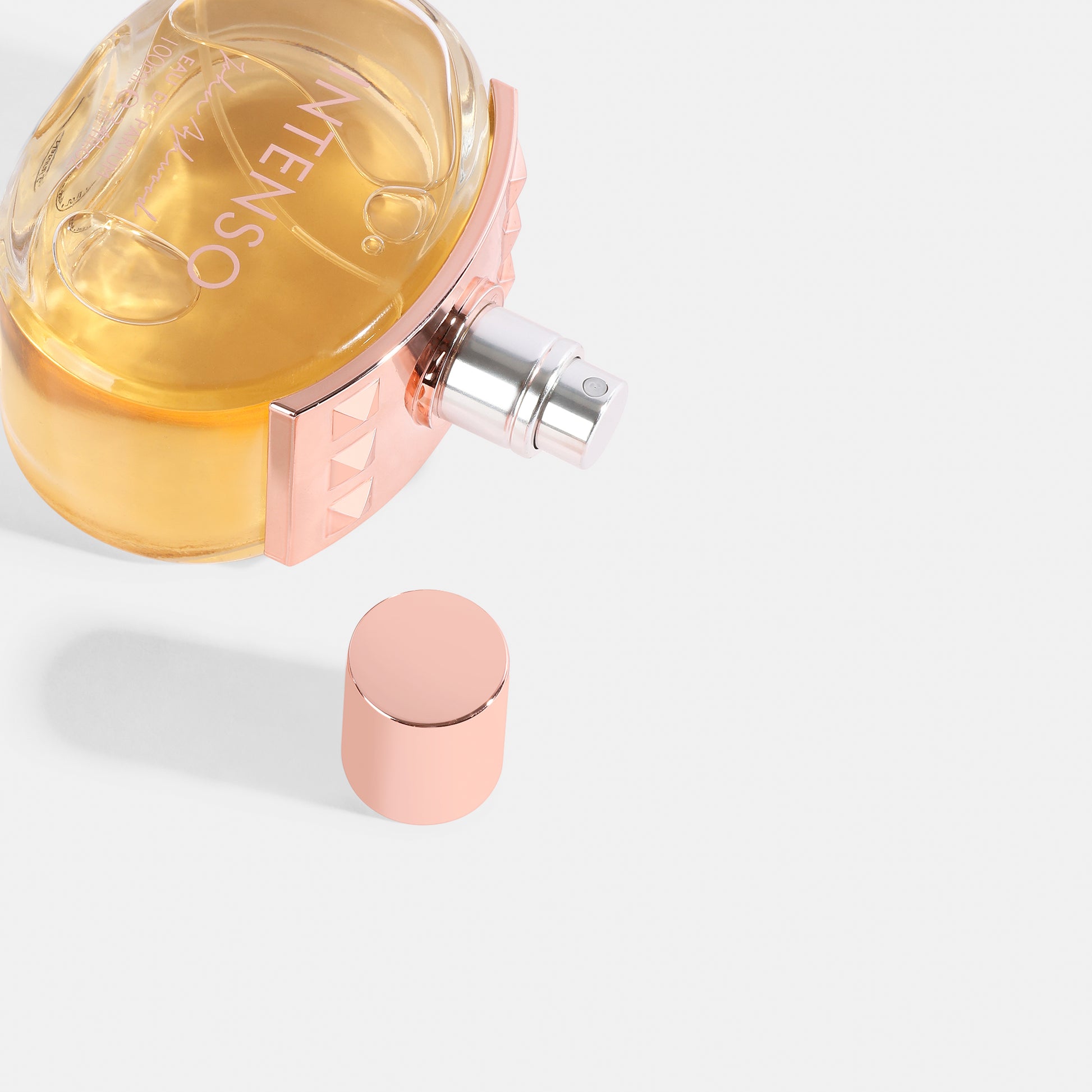 INTENSO Perfume bottle with rose gold cap on a light gray background