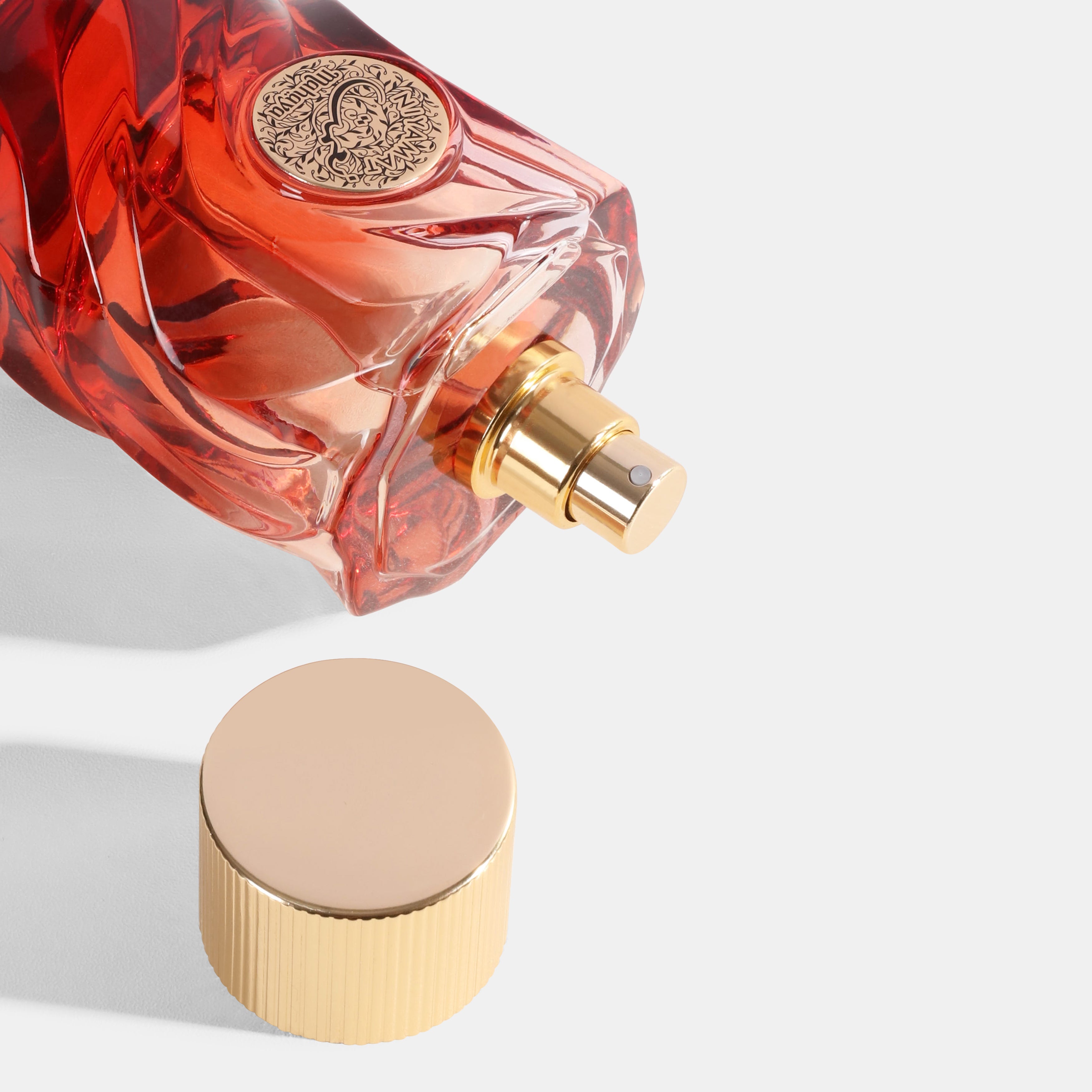 Niyamat_Rouge Red perfume bottle with gold cap on a light gray background. House Of Perfumes India