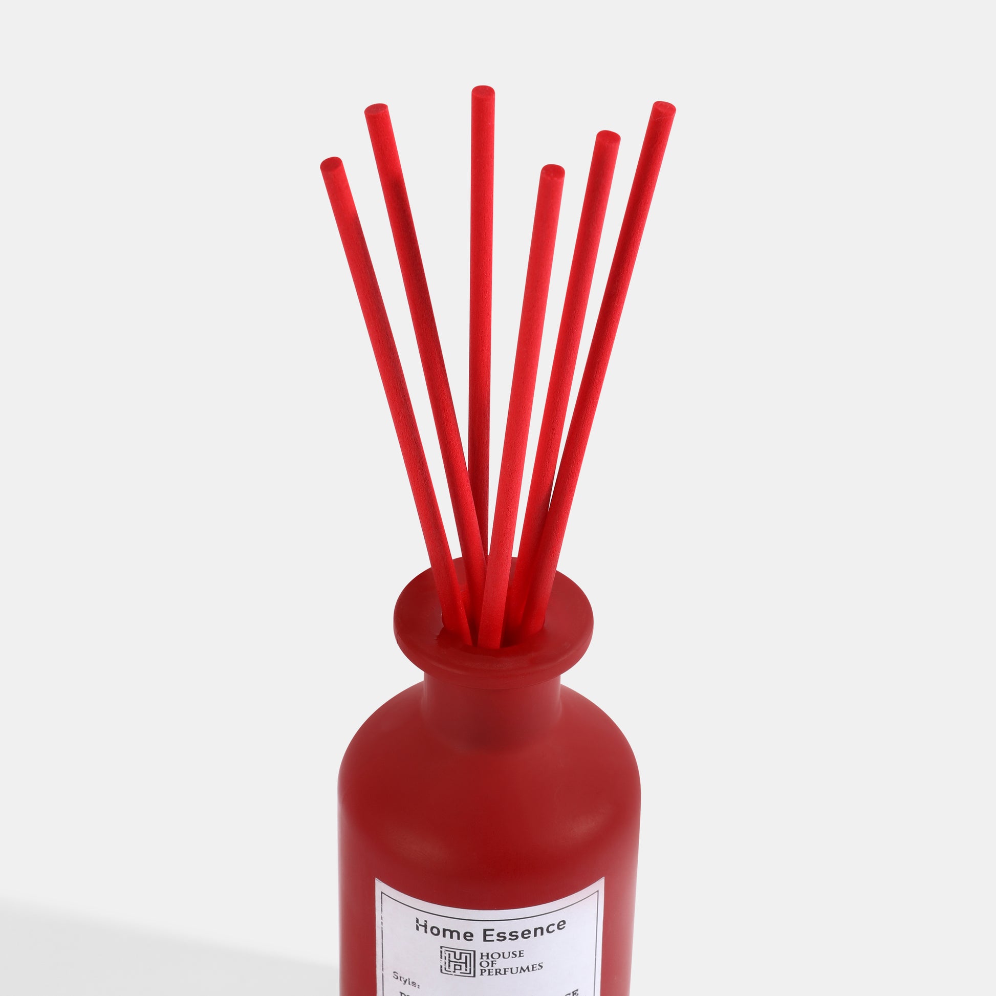 Red diffuser with sticks on a white background
